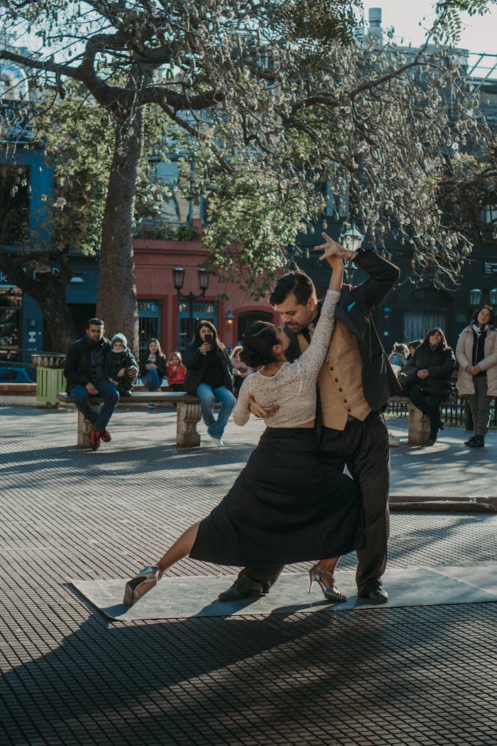A passionate couple performing tango on a bustling urban street, surrounded by spectators.